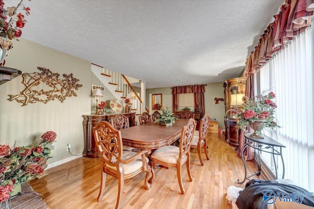 dining room featuring light hardwood / wood-style flooring and a textured ceiling