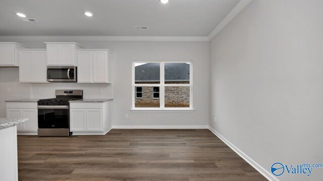 kitchen featuring ornamental molding, white cabinets, stainless steel appliances, and visible vents