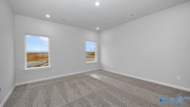 unfurnished room featuring baseboards, visible vents, recessed lighting, and carpet flooring