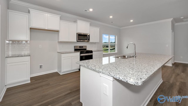 kitchen with a center island with sink, white cabinets, a sink, and stainless steel appliances