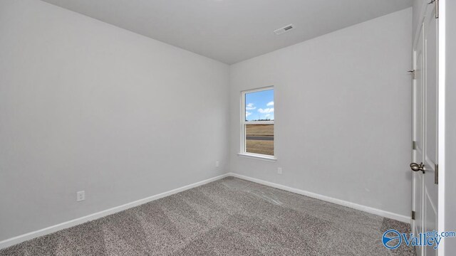 carpeted spare room featuring baseboards and visible vents