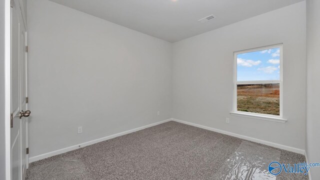 carpeted empty room featuring baseboards and visible vents
