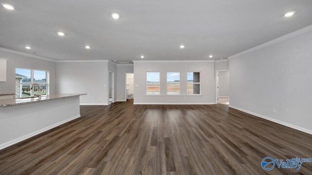 unfurnished living room with baseboards, recessed lighting, and dark wood finished floors