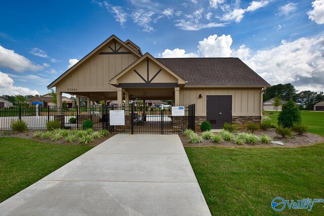 view of home's community with a gate, fence, and a lawn