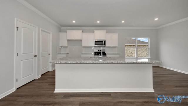 kitchen with white cabinetry, stainless steel appliances, a sink, dark wood-style floors, and an island with sink