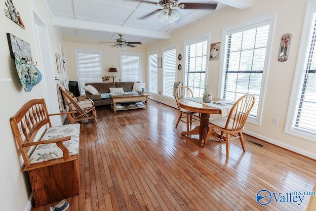 interior space featuring plenty of natural light, a ceiling fan, visible vents, light wood finished floors, and coffered ceiling