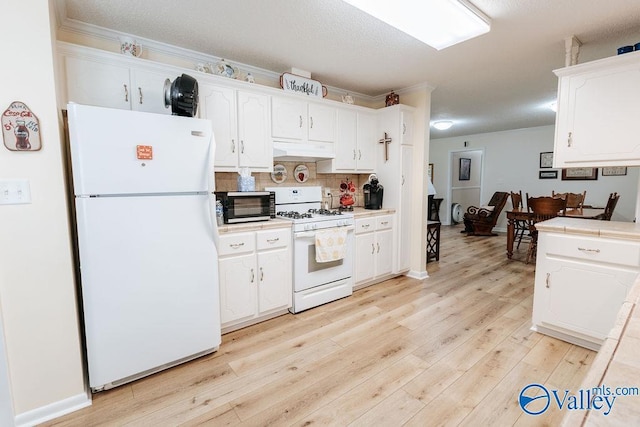 kitchen with backsplash, white cabinets, light wood finished floors, under cabinet range hood, and white appliances