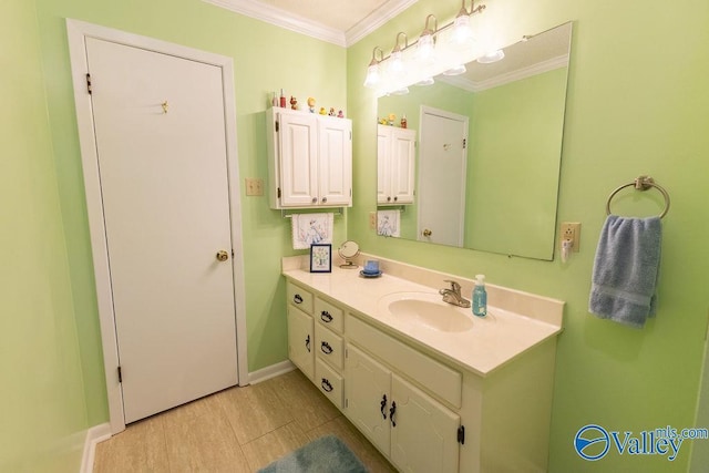 bathroom with crown molding, baseboards, and vanity