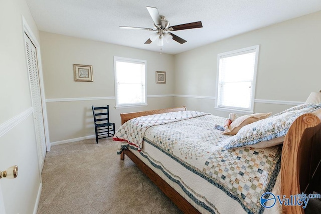 bedroom with ceiling fan, baseboards, carpet, and a closet