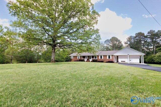 ranch-style house featuring a garage, driveway, and a front yard