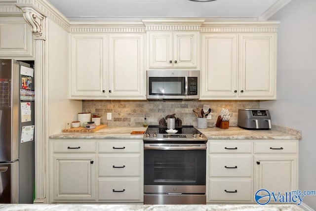 kitchen with tasteful backsplash, crown molding, cream cabinets, and stainless steel appliances