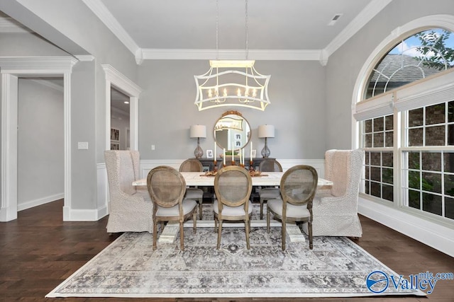 dining space with dark hardwood / wood-style flooring, an inviting chandelier, and ornamental molding