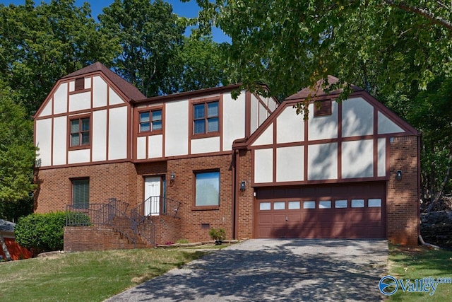 english style home with driveway, stucco siding, a garage, crawl space, and brick siding