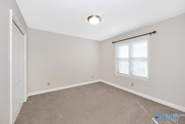 unfurnished bedroom featuring a closet, baseboards, and carpet floors