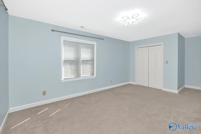 unfurnished bedroom featuring a closet, baseboards, and carpet