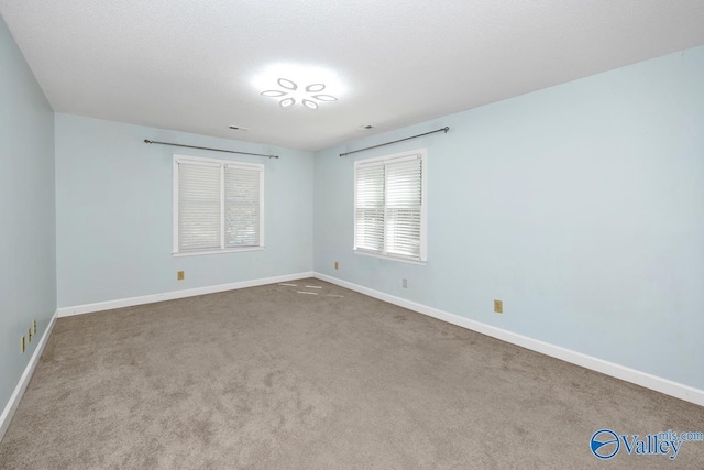 carpeted empty room with baseboards