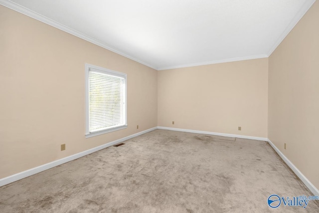 carpeted empty room with visible vents, baseboards, and ornamental molding