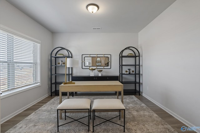 office area featuring baseboards, visible vents, and wood finished floors