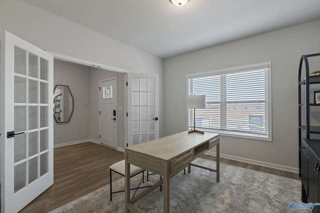 home office featuring lofted ceiling, baseboards, wood finished floors, and french doors