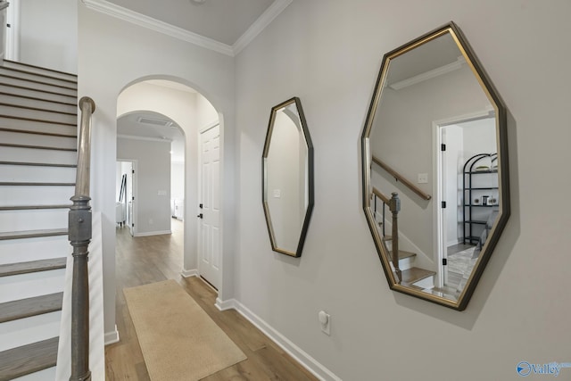 hallway featuring ornamental molding, stairway, and wood finished floors