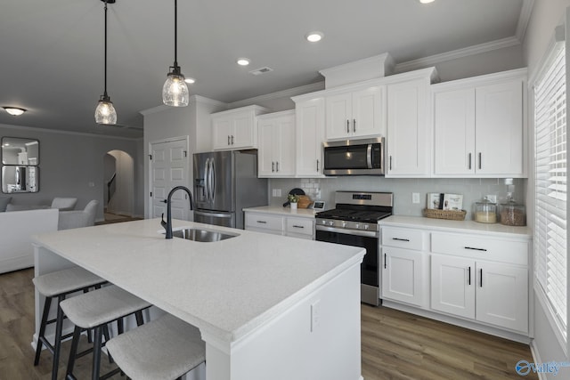 kitchen with plenty of natural light, arched walkways, stainless steel appliances, and a sink