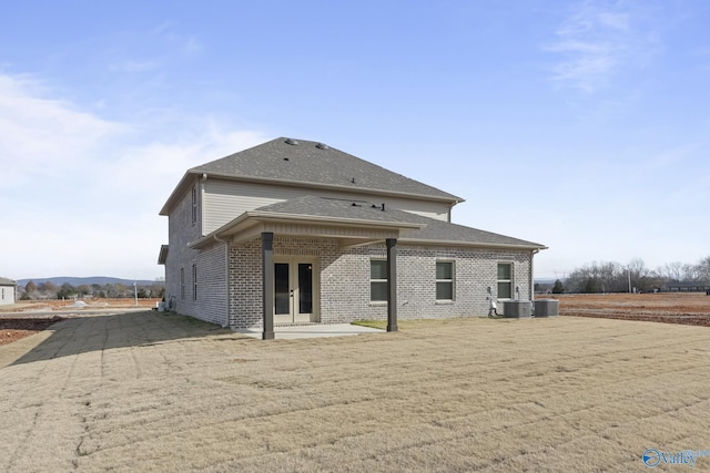 back of house featuring central AC, french doors, a patio, and brick siding