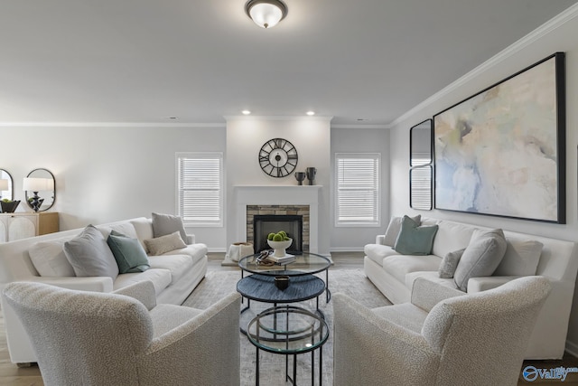 living room featuring a stone fireplace, recessed lighting, wood finished floors, baseboards, and crown molding