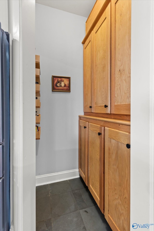 interior space with dark tile patterned floors and baseboards