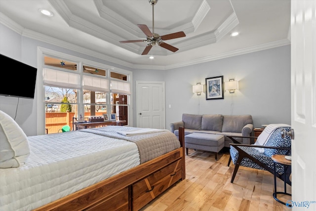 bedroom featuring ornamental molding, a tray ceiling, recessed lighting, light wood-style floors, and ceiling fan