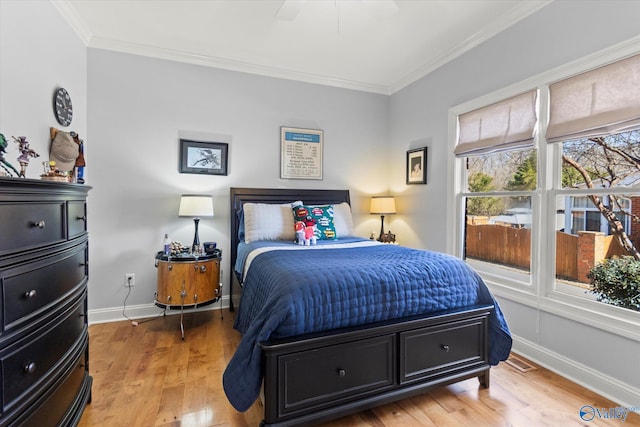 bedroom with visible vents, ornamental molding, light wood-style floors, baseboards, and ceiling fan