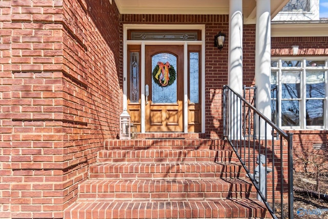 view of exterior entry with brick siding