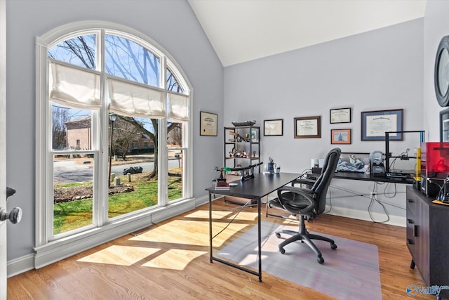 office featuring wood finished floors, baseboards, and high vaulted ceiling