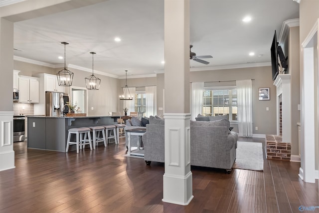 living room with dark wood-style floors, plenty of natural light, and ceiling fan with notable chandelier