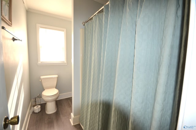 bathroom featuring ornamental molding, toilet, and hardwood / wood-style floors