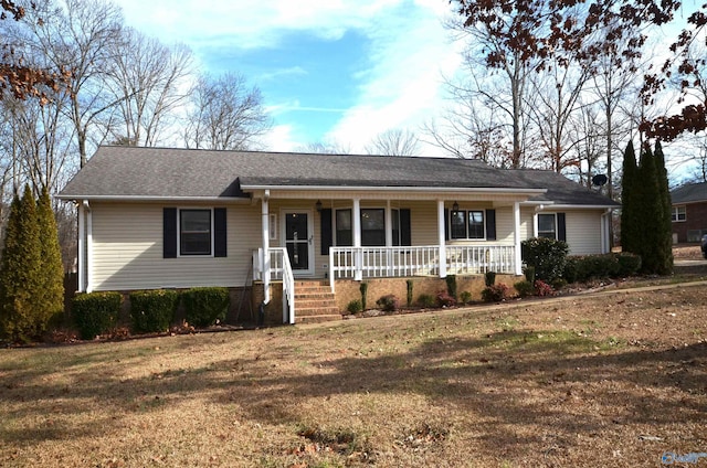 ranch-style house featuring covered porch and a front lawn