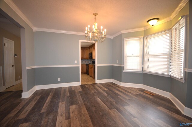 unfurnished dining area with dark hardwood / wood-style flooring, crown molding, and a chandelier