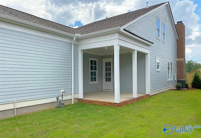 rear view of property with a yard, cooling unit, and a patio area