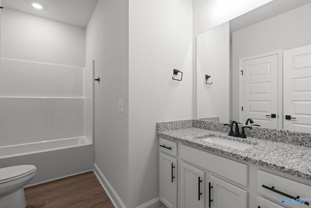 full bathroom with shower / bathing tub combination, vanity, wood-type flooring, and toilet