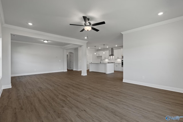 unfurnished living room featuring ceiling fan, dark hardwood / wood-style flooring, and crown molding