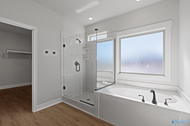 bathroom with hardwood / wood-style floors, independent shower and bath, and a healthy amount of sunlight