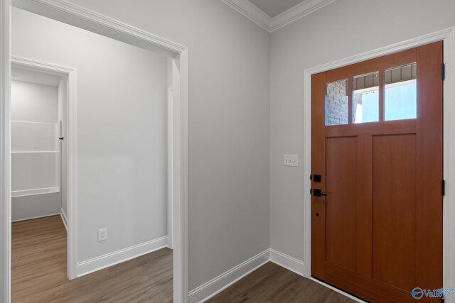 foyer entrance with wood-type flooring and crown molding