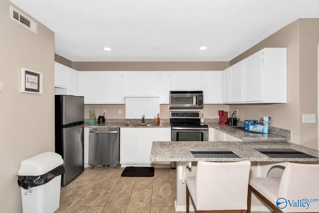 6616 Willow Pointe Dr Unit A, Huntsville, AL 35806 - kitchen with stainless steel appliances, a sink, a peninsula, white cabinetry, and recessed lighting