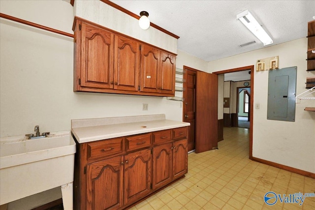 143 Maze Dr, Hartselle, AL 35640 - kitchen with electric panel, light countertops, brown cabinets, light flooring, and a textured ceiling