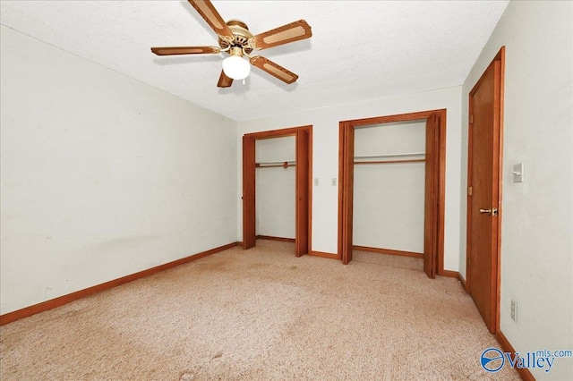 143 Maze Dr, Hartselle, AL 35640 - unfurnished bedroom featuring multiple closets, light carpet, ceiling fan, baseboards, and a textured ceiling
