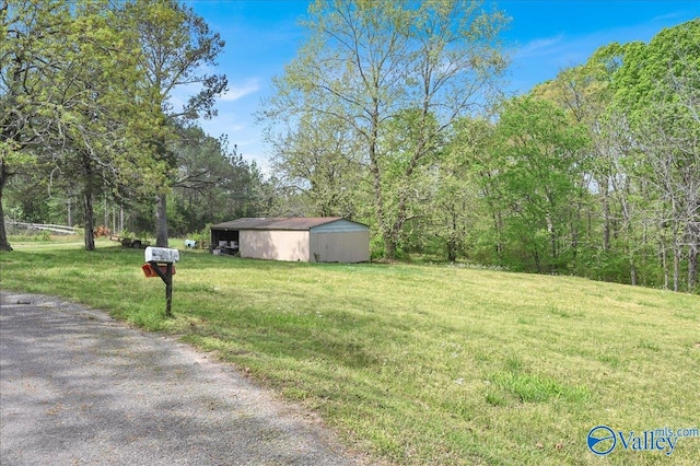 143 Maze Dr, Hartselle, AL 35640 - view of grassy yard featuring a pole building, an outbuilding, and a wooded view