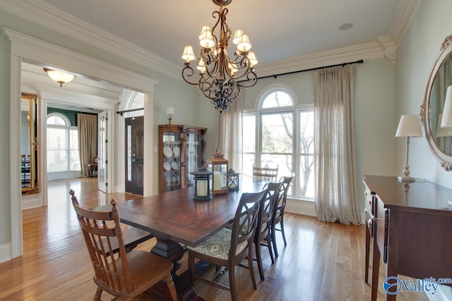 dining room with a chandelier, crown molding, and light wood-type flooring