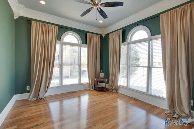 spare room featuring crown molding, recessed lighting, wood finished floors, and baseboards