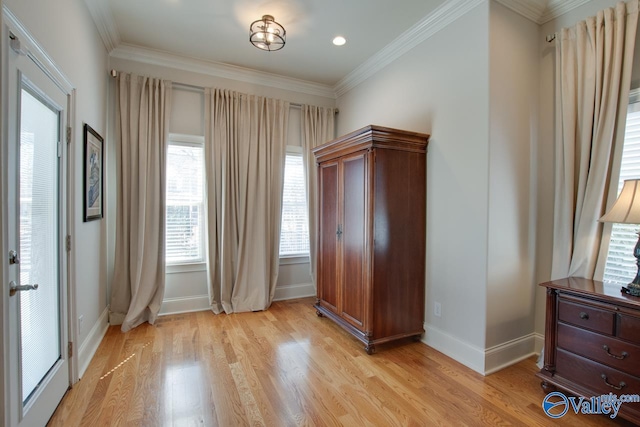 bedroom with crown molding, light wood-style flooring, and baseboards