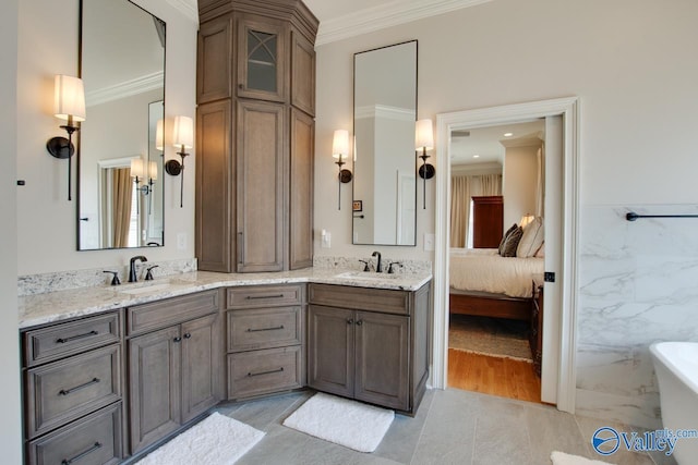 bathroom featuring crown molding, a soaking tub, and a sink