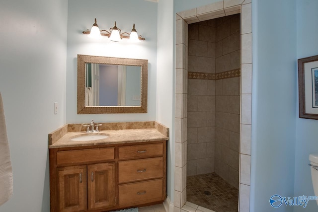 bathroom with vanity, toilet, and a tile shower